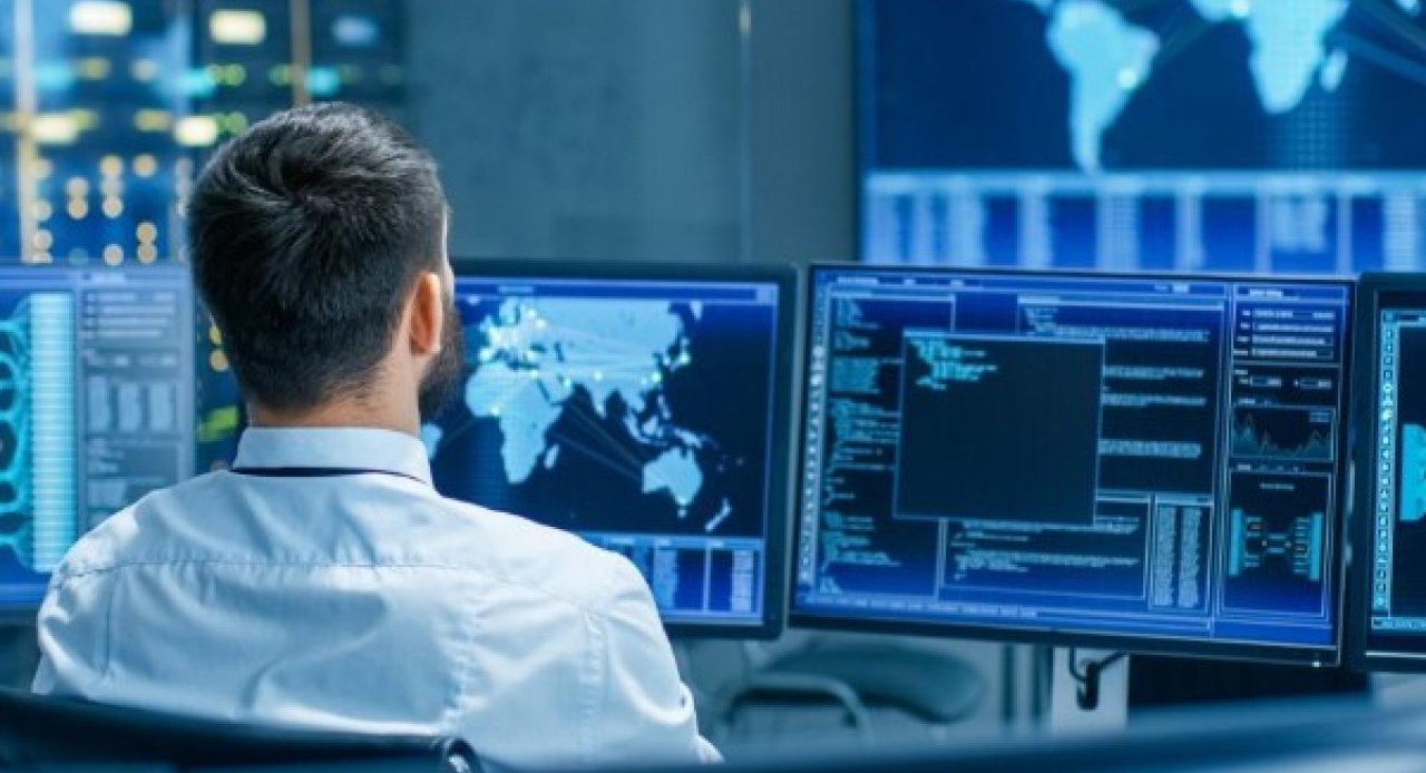 Un homme face à plusieurs écrans